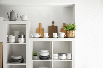 Fototapeta na wymiar Kitchen shelving with dishes on white wall background