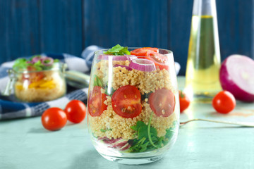 Glass of quinoa and vegetables on table