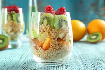 Quinoa and fruits in glass on table