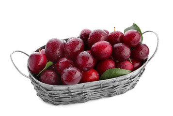 Ripe plums in basket on white background