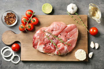 Board with fresh raw steak with thyme on table