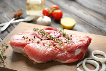 Board with fresh raw steak on table