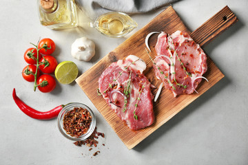 Board with fresh raw steaks on table