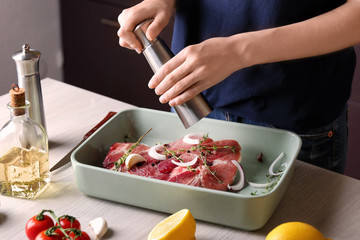 Woman cooking steak in kitchen