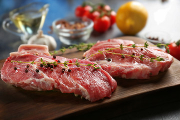 Board with fresh raw steaks on table