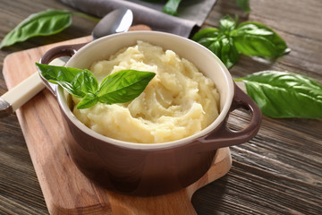 Pot with mashed potatoes on wooden table