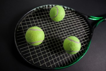 High angle view of fluorescent yellow tennis racket and balls