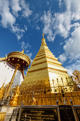 Wat Phra That Cho Hae Buddhism Temple with golden pagoda on blue sky background. Places worship of buddhists and attractions famous religion at Phrae Province, Thailand