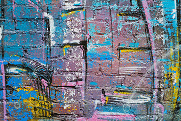 Abstract colorful (blue, purple, yellow, white and black)painted brick wall as background, texture