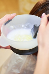Hands mixing hair dye. Bowl with hair dye, macro.