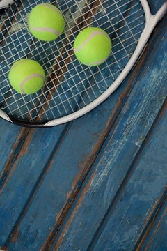 High angle view of fluorescent yellow balls on tennis racket