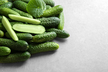 Many green fresh cucumbers on gray background