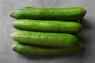 Many green fresh cucumbers on gray table