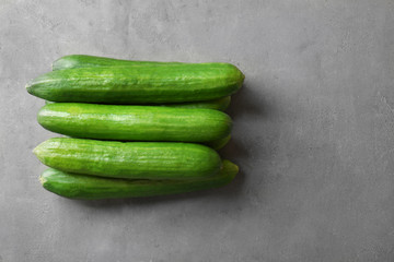 Many green fresh cucumbers on gray table