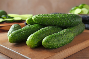 Green fresh cucumbers on wooden board