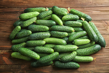 Many green fresh cucumbers on wooden background