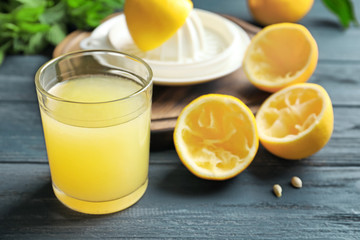 Glass of fresh lemon juice on wooden table