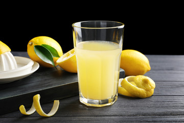 Glass of fresh lemon juice on wooden table