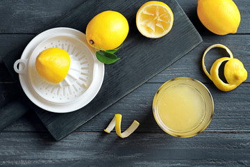 Composition with lemon juice and squeezer on wooden background