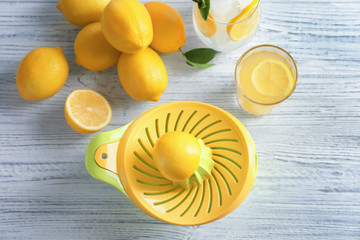 Composition with lemon juice and squeezer on wooden background