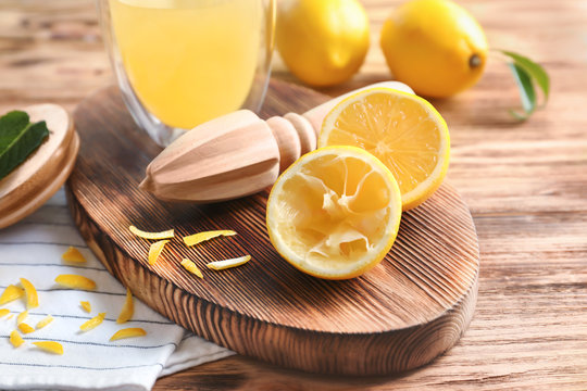 Fresh lemons and squeezer on wooden table