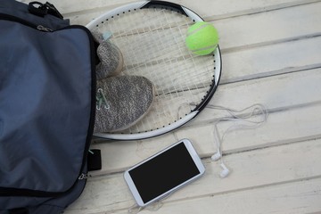 High angle view of gray bag on sports shoes with tennis gear by - Powered by Adobe