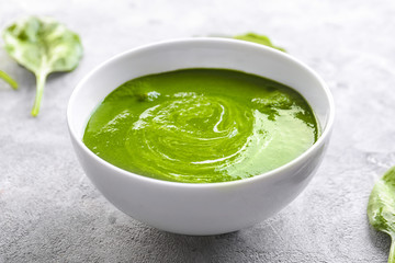 Bowl with tasty spinach soup on table