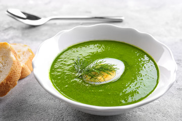 Plate with tasty spinach soup on table