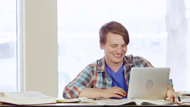 Portrait of smiling student using laptop