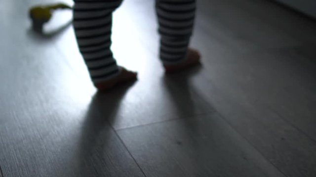 Little legs of toddler learning to walk and keep balance