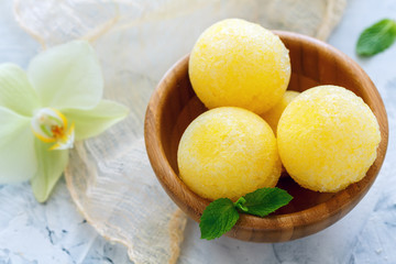 Balls of melon sorbet in a wooden bowl.