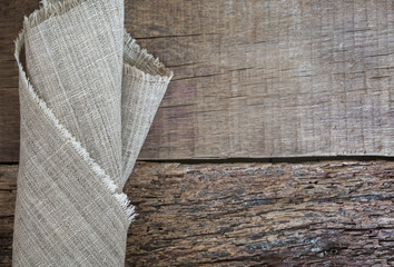 Folded gray napkin on a wooden background. Burlap texture. Pattern  fabric textile. Texture background