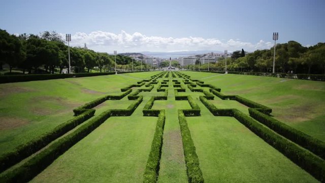 Miradouro Park Eduardo VII in Lisbon, Portugal, Europe. Big grass gardens of the park, Marquess of Pombal Statue and Avenida da Liberdade. Sunny day.