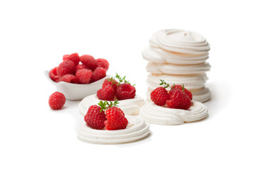 Mini  Pavlova meringue nests with raspberries and thyme on isolated on white