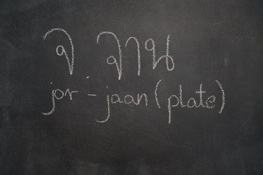 Thai letter written with white chalk on blackboard