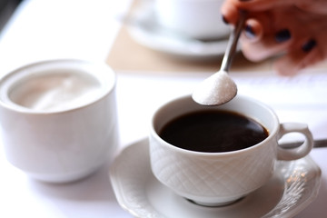 Unhealthy drink with woman hand adding too much sugar on a coffee