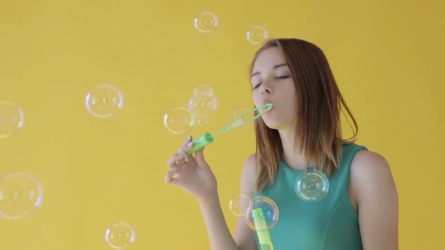 Young cute girl blows bubbles, pretty woman, slow motion  