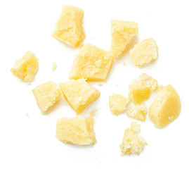 Parmesan cheese pieces on white background. Italian cheese slices. Top view.