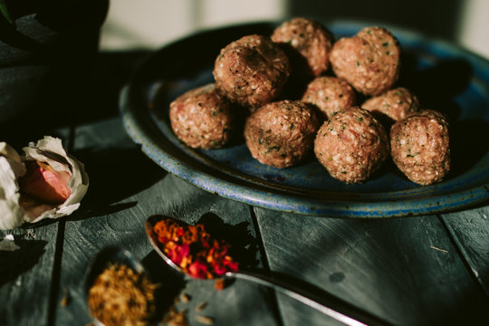 Uncooked meatballs and spices.