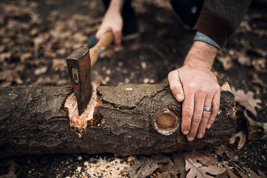 Man using an axe to cut wood