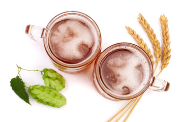 glass of foamy beer with hop cones and wheat isolated on white background. Top view
