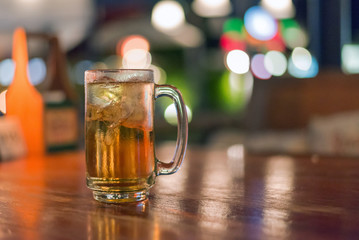 blurred glass of beer in bar background