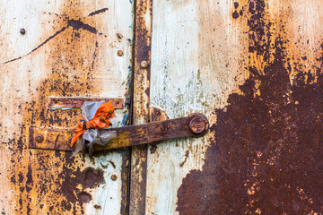 Rusty metal wall and door with peeling paint.