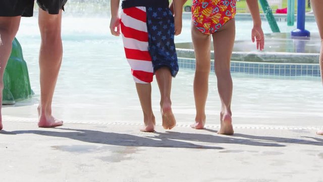 Close up of young family walking into the pool