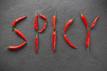 Spicy / Geschrieben mit Chilischoten auf Schieferplatte