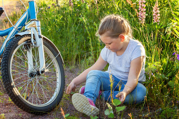 Smiling little girl near a bicycle