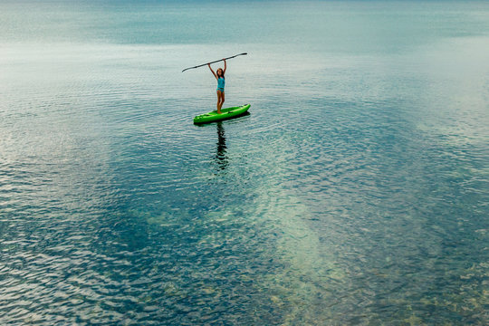 tween girl having fun in the sea with her kayak