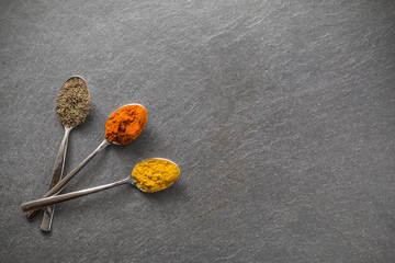 Drei L&ouml;ffel auf Schieferplatte mit Paprika, Curry, Oregano/ Variante 01