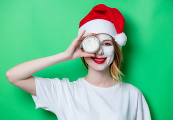 Fototapeta na wymiar Woman using eye patch for her eyes in Santa Claus hat