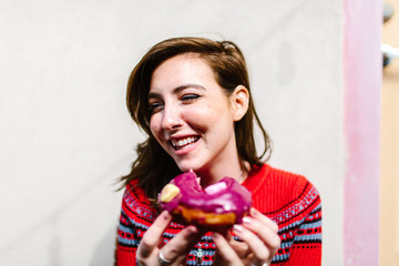 Cute girl eating a glazed donut